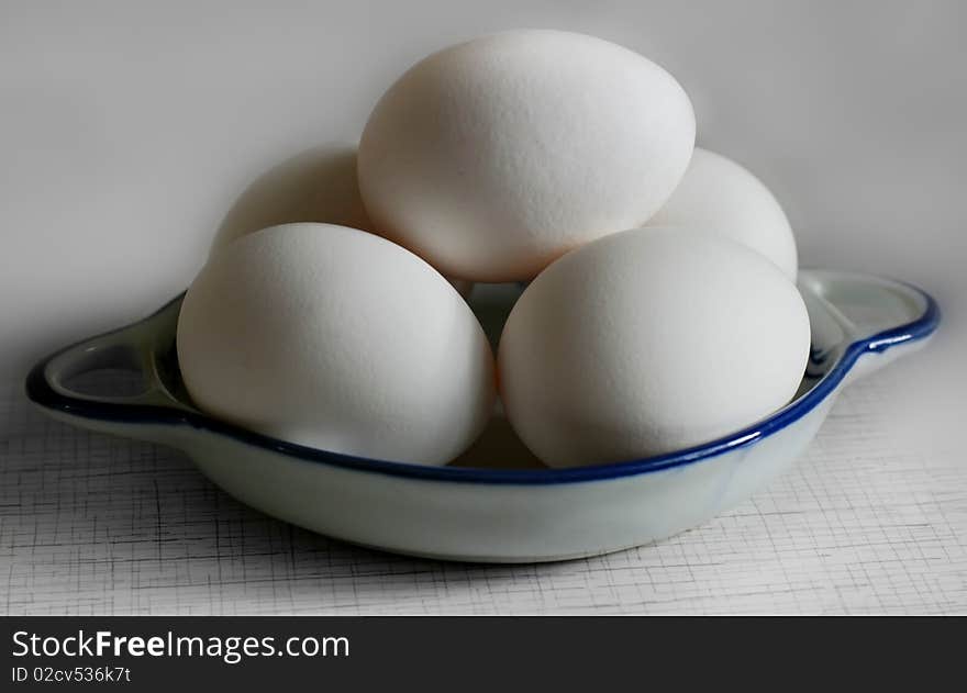 Five white eggs on a plate. Five white eggs on a plate