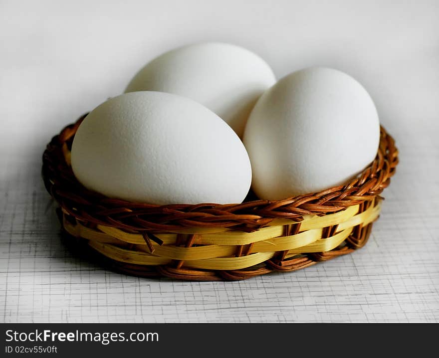 Three white eggs in a basket. Three white eggs in a basket