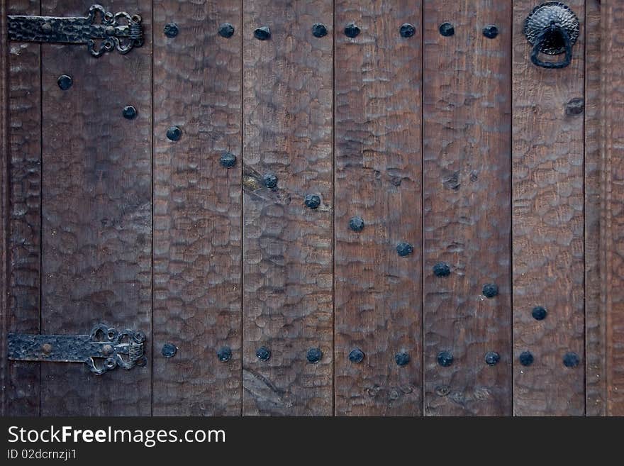 Old wooden door with metal knob and nails