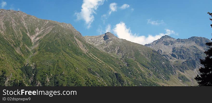 Wide panoramic of mountains with blue sky above. Wide panoramic of mountains with blue sky above