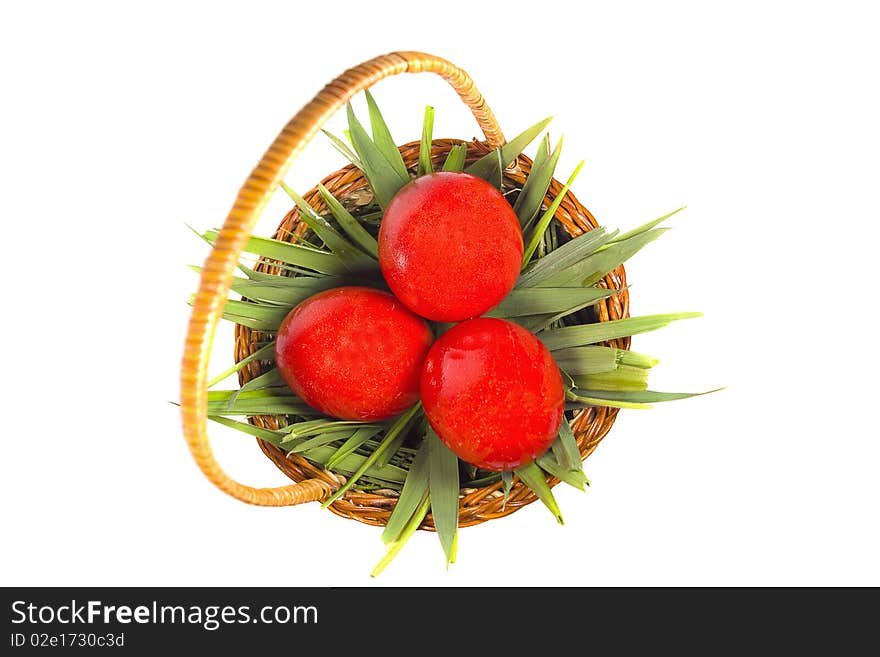 Easter basket with green grass and three red eggs isolated on white background. Easter basket with green grass and three red eggs isolated on white background