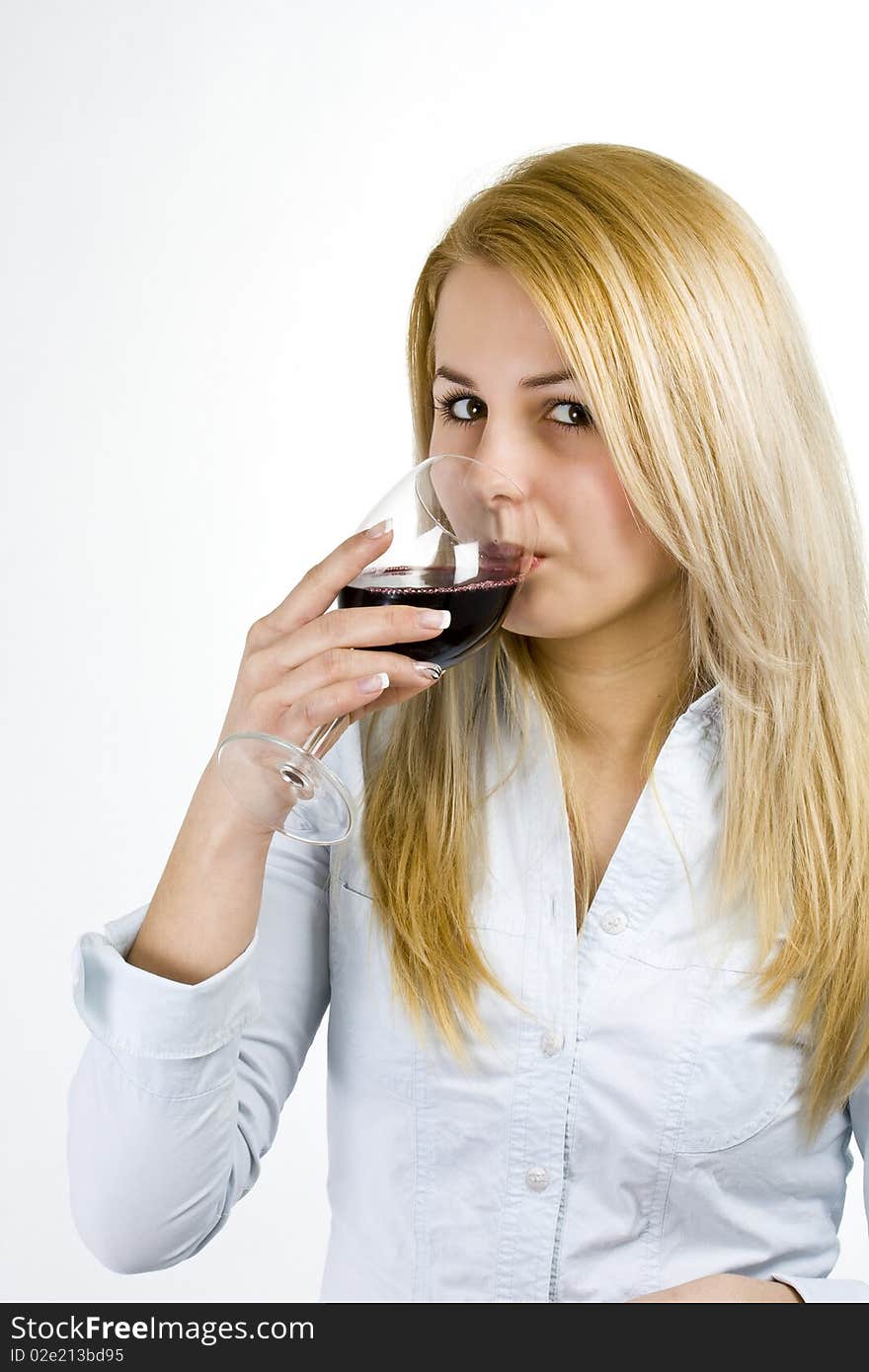 Beautiful young girl drinks wine from glass