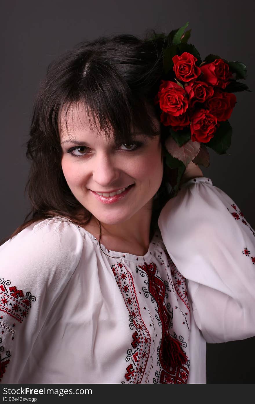 Young smiling girl in national ukrainian blouse with red flowers. Young smiling girl in national ukrainian blouse with red flowers