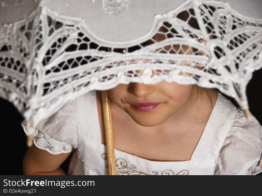 Smiling girl in the white dress with the retro umbrella on the brown background. Smiling girl in the white dress with the retro umbrella on the brown background