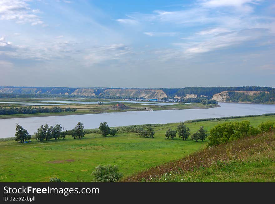 View from the hill to the river valley and high waterside in distance. View from the hill to the river valley and high waterside in distance