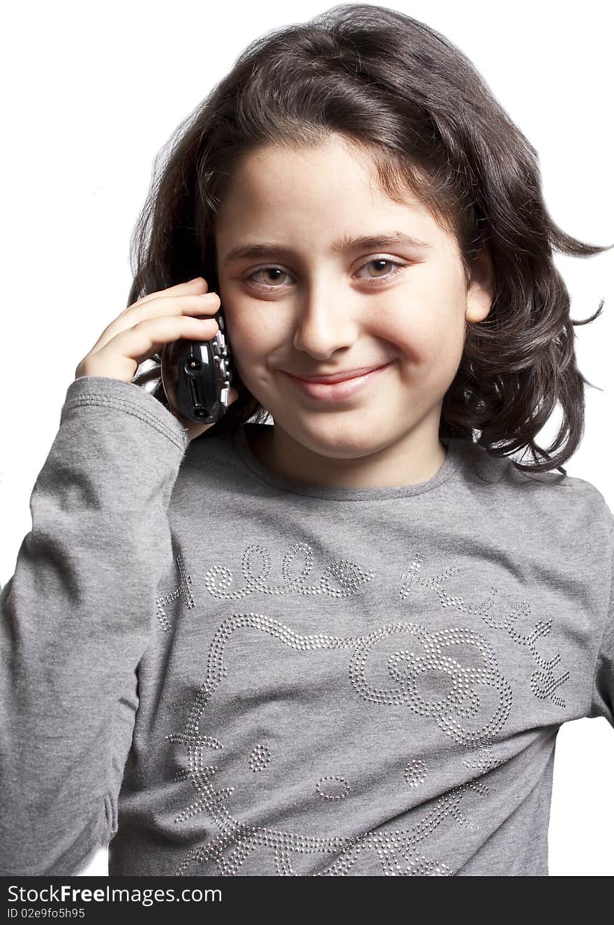 A teen is talking on the phone with a lovely smile on her face. A teen is talking on the phone with a lovely smile on her face