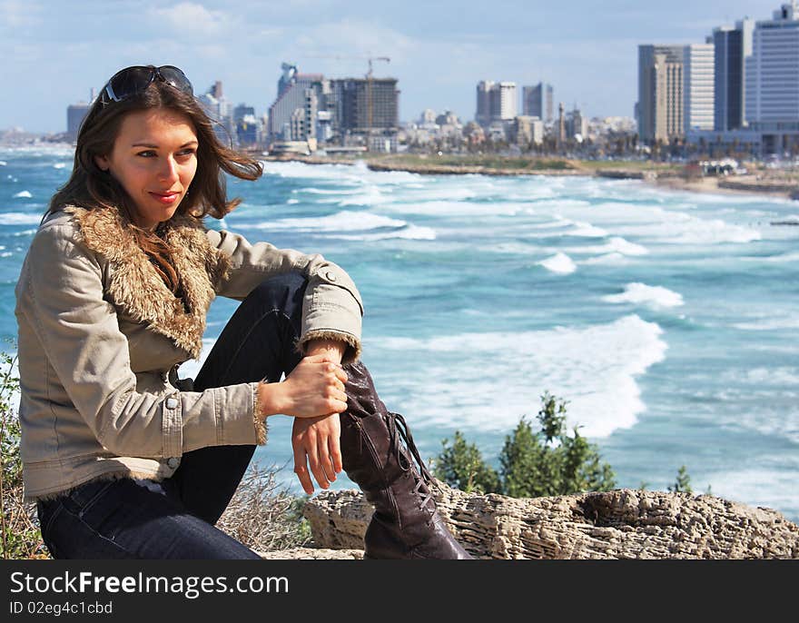 Beautiful young girl on the background of the city and sea. Beautiful young girl on the background of the city and sea