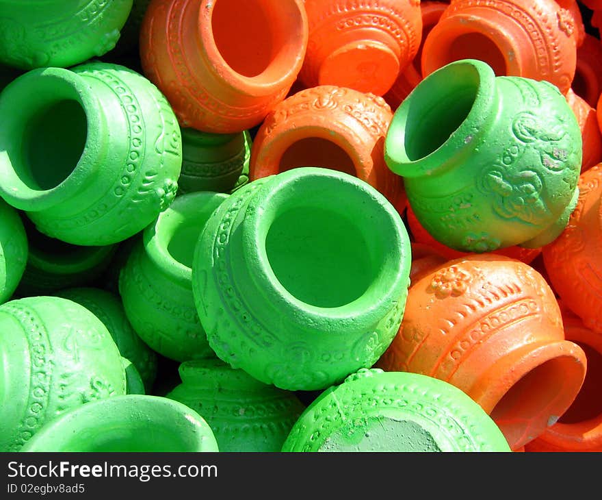 Green and Orange coloured clay pots in stock on display