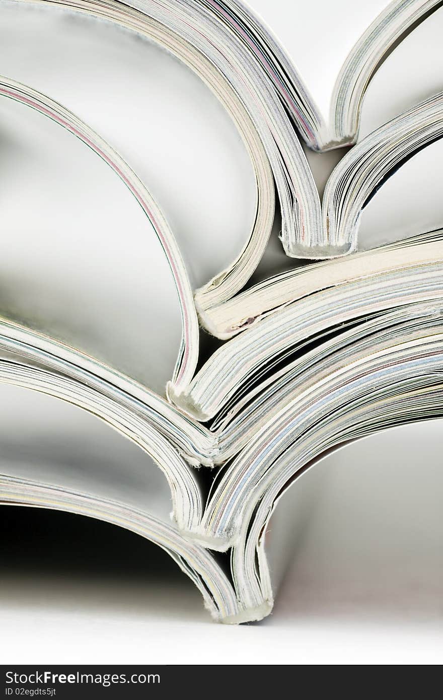 Stack of colorful magazines on white background