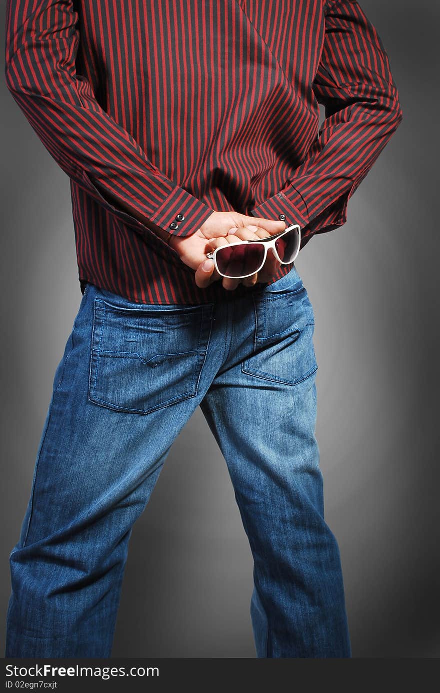 Beautiful blue jeans and red shirt wearing a model with glasses isolated on a gray background.