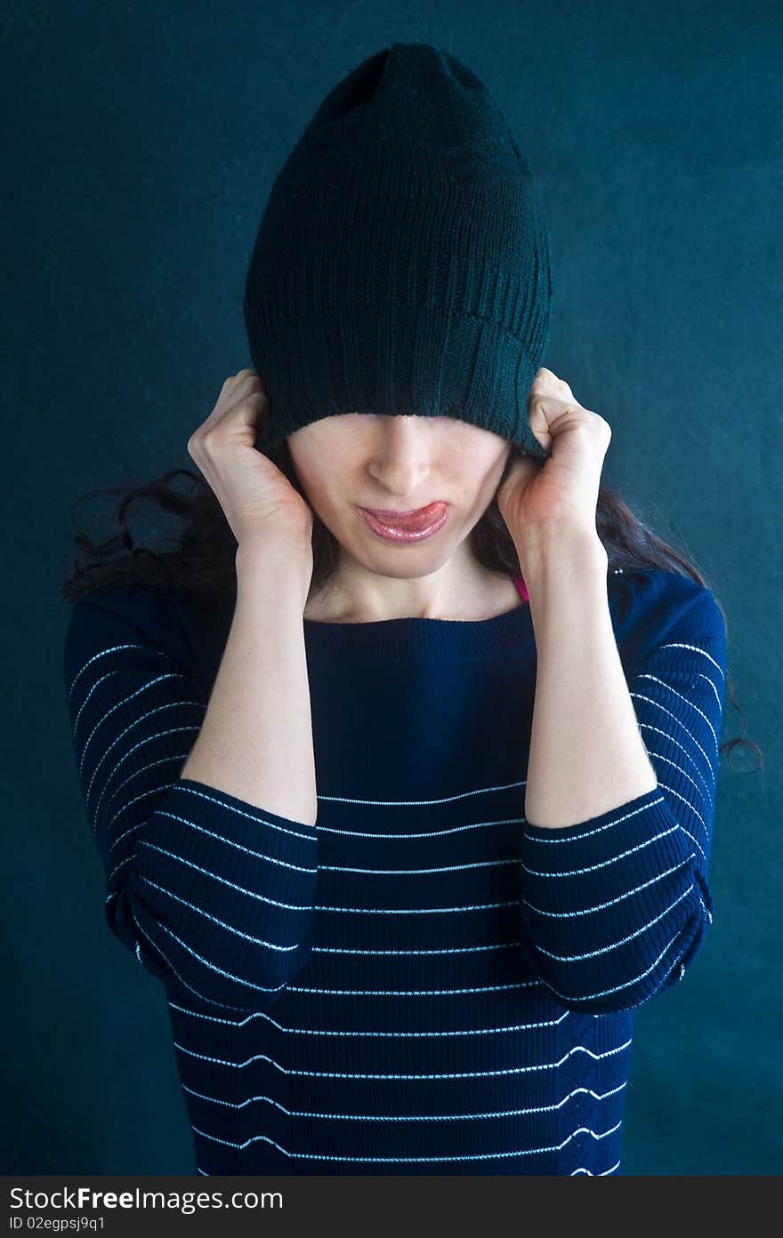 Picture of woman puts on a hat and put out the tongue. Picture of woman puts on a hat and put out the tongue