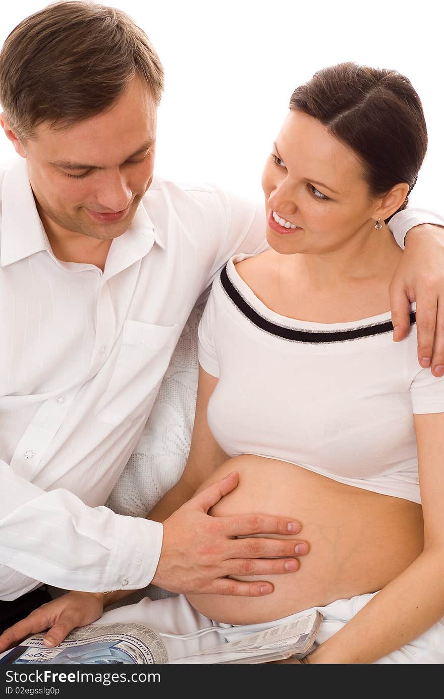 Man with his pregnant wife were sitting on a white background