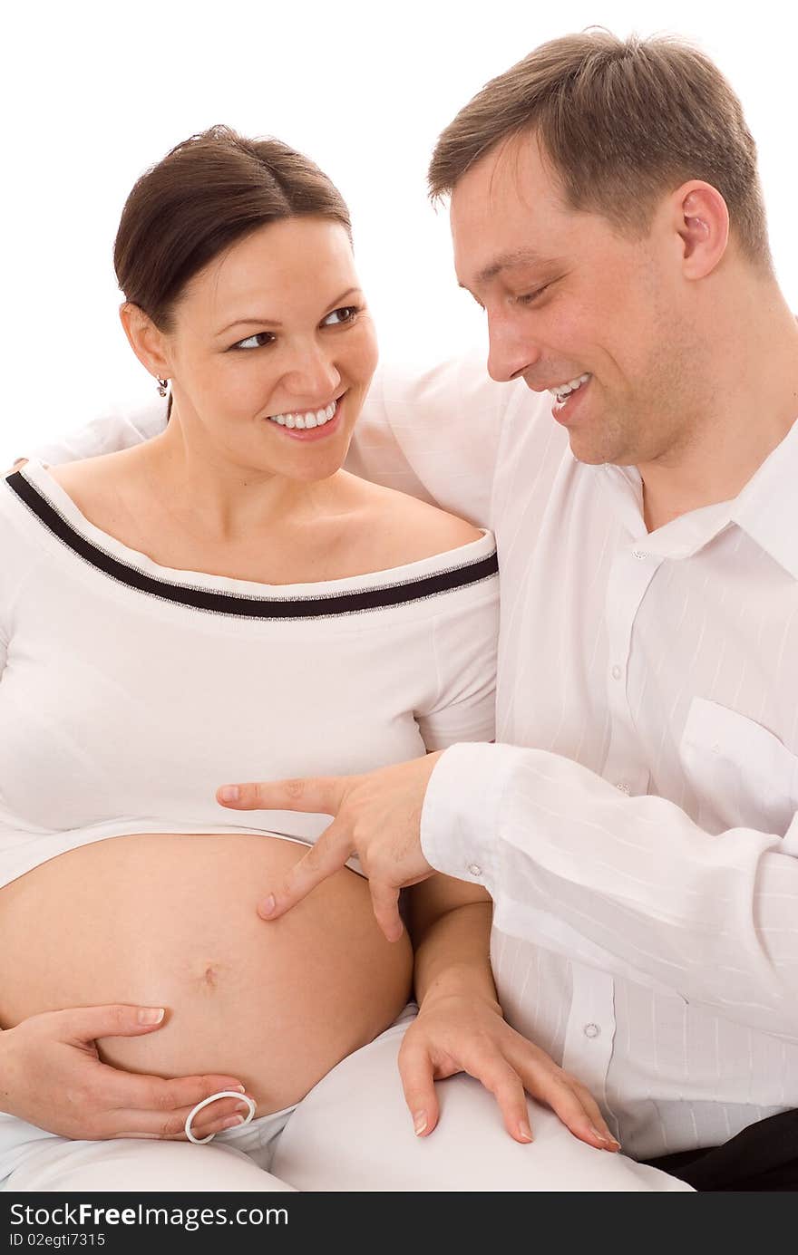 Man with his pregnant wife were sitting on a white