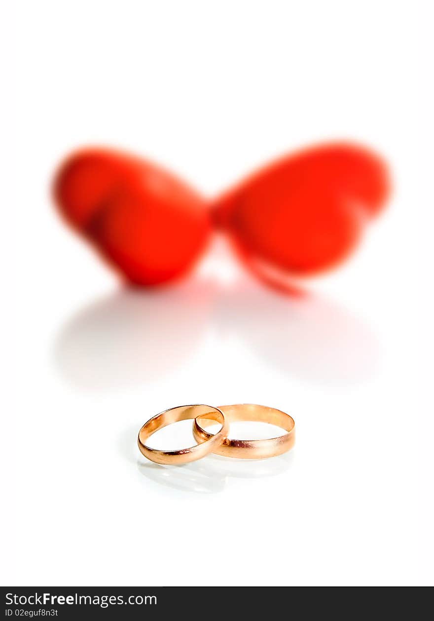 Gold rings and hearts isolated on white