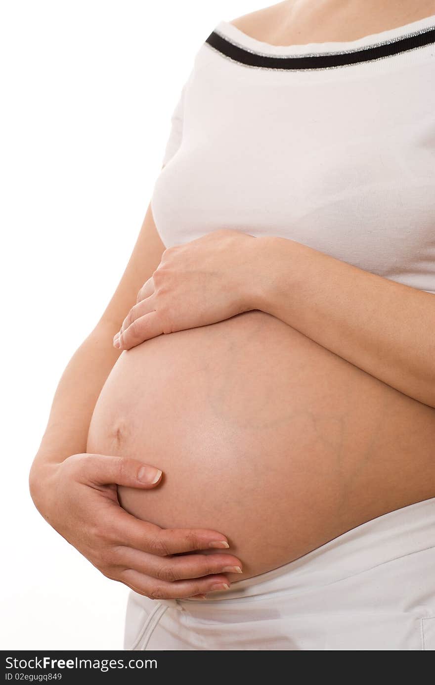 Pregnant woman holding her hands on stomach on a white background. Pregnant woman holding her hands on stomach on a white background