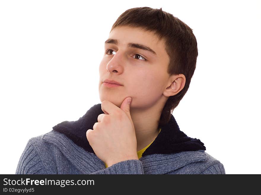 Handsome young man stands and thinks on a white background