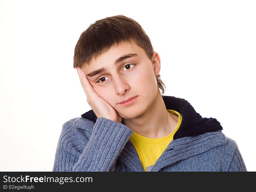 Handsome young teenager standing and thinking on a white background