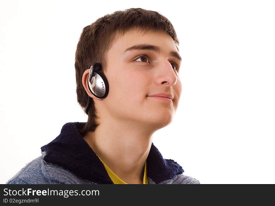 Beautiful teenager in a blue blouse with headphones on white background. Beautiful teenager in a blue blouse with headphones on white background