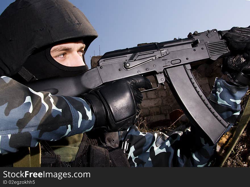 Soldier shooting with an AK47 automatic rifle from covered position. Soldier shooting with an AK47 automatic rifle from covered position