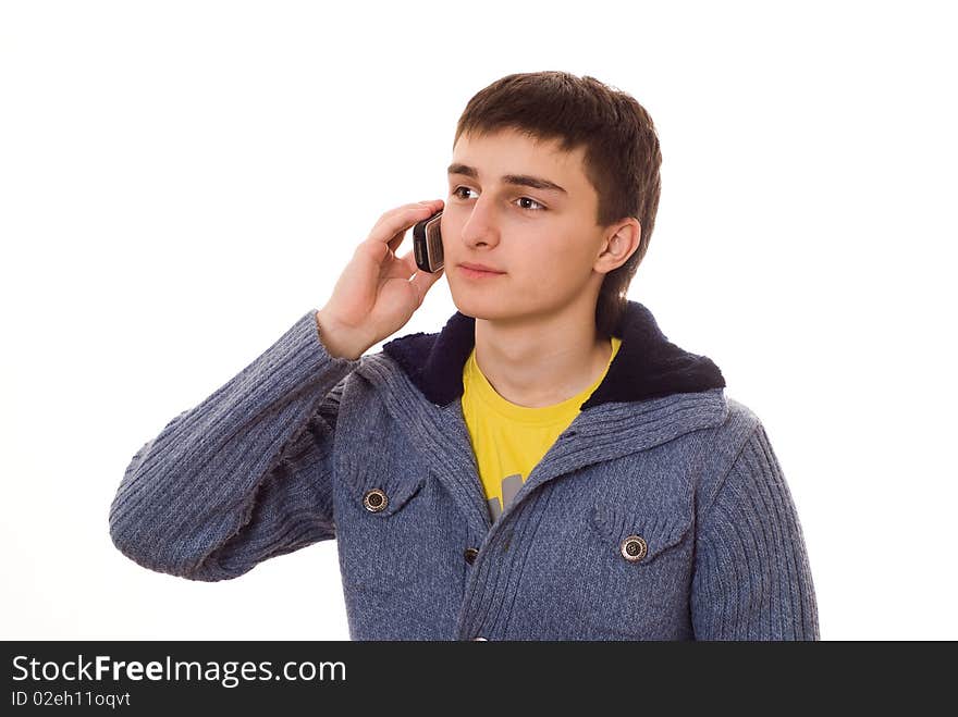 Beautiful teenager in a blue blouse talking on the phone on a white background