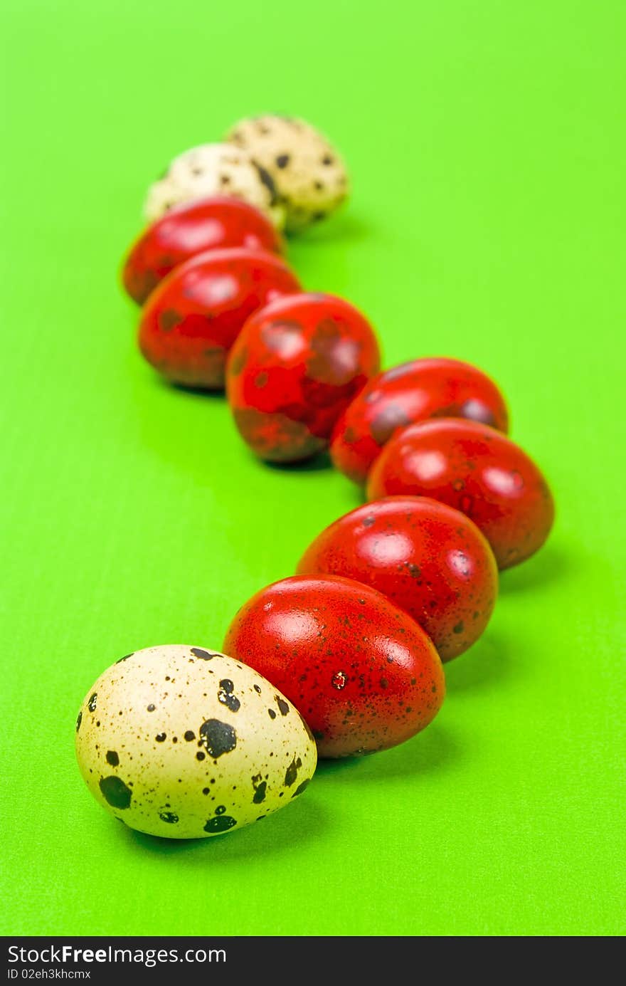 Red and white easter eggs on green background