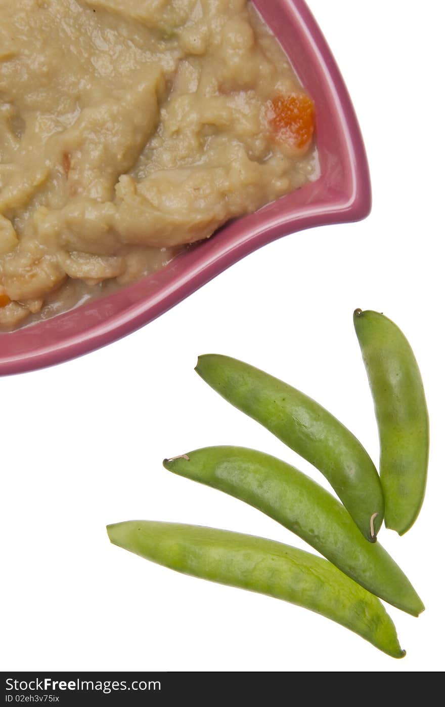 Split pea soup garnished with sugar snap peas.  Isolated on white with a clipping path.