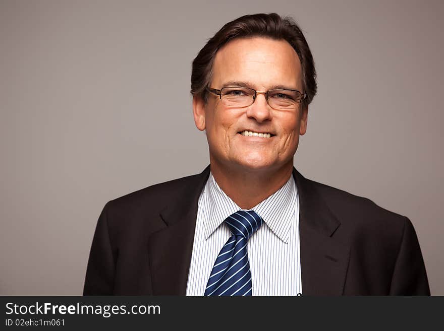 Handsome Businessman Smiling in Suit and Tie Isolated on a Grey Background. Handsome Businessman Smiling in Suit and Tie Isolated on a Grey Background.