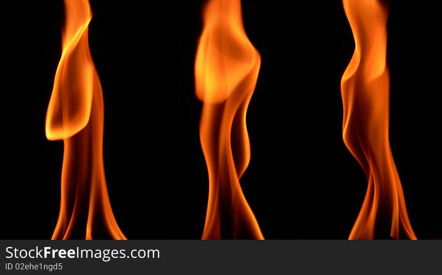 Several high orange flames on black background. Several high orange flames on black background