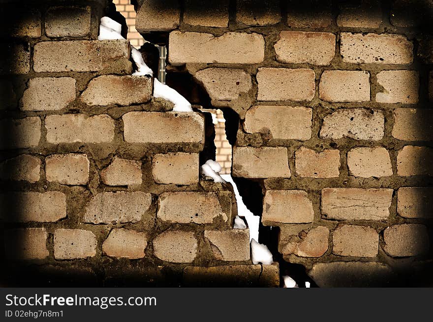 Crack in a laying from a grey old brick covered with a snow. Crack in a laying from a grey old brick covered with a snow