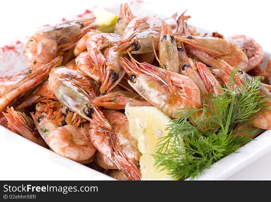 Shrimps with dill and lemon on white plate