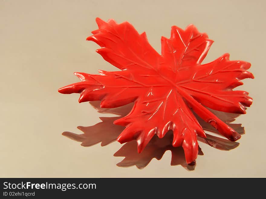 Red maple artificial leaf on glass