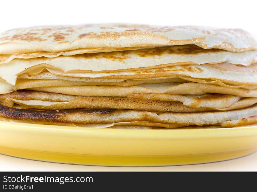 Pancakes on yellow plate on white ground