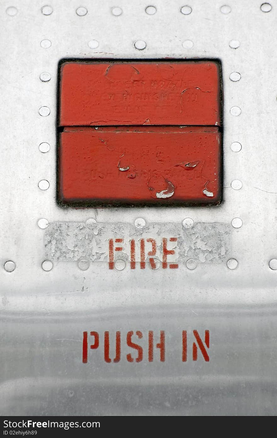 Fire emergency button embedded in an old metal panel. Fire emergency button embedded in an old metal panel