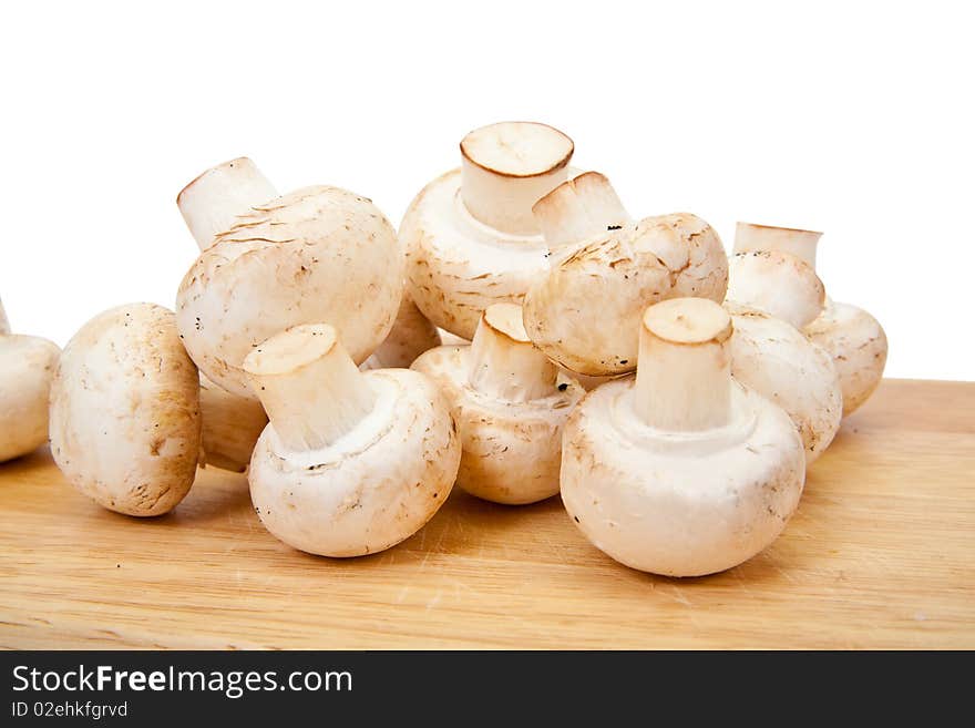 Champignon mushroom on cutting board over white