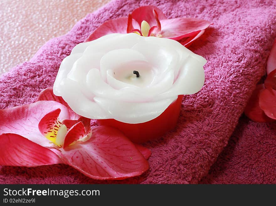 A set of spa items with a decorative red flower and candles