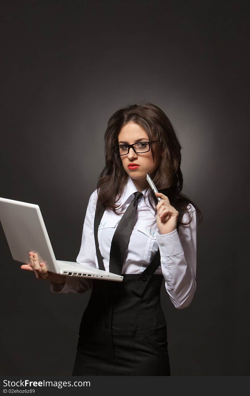 Portrait of a young attractive business woman in glasses with silver pen and white notebook at hands