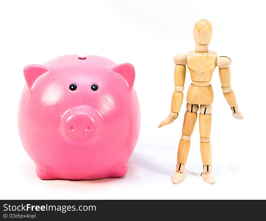 Pink piggy bank and wooden mannequin person stand beside each other on a white background. Pink piggy bank and wooden mannequin person stand beside each other on a white background.