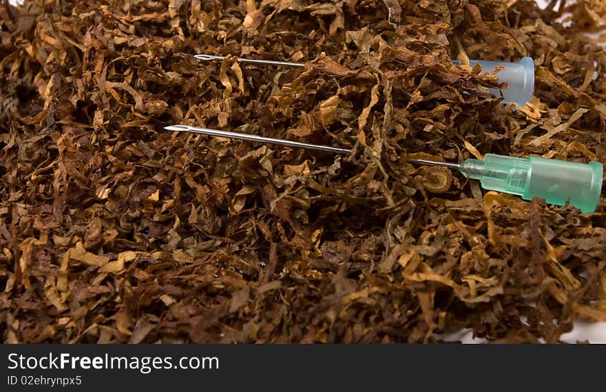 Abstract Smoking Addiction concept of pile of shredded tobacco with hypodermic needle. Abstract Smoking Addiction concept of pile of shredded tobacco with hypodermic needle.