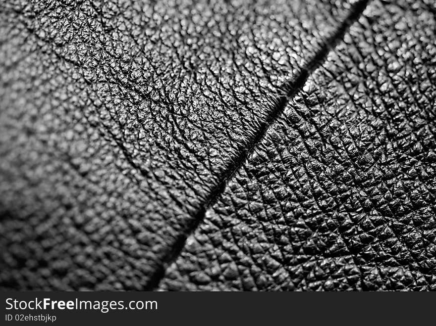 Black leather with a seam running diagonally. Macro photography. Black leather with a seam running diagonally. Macro photography.