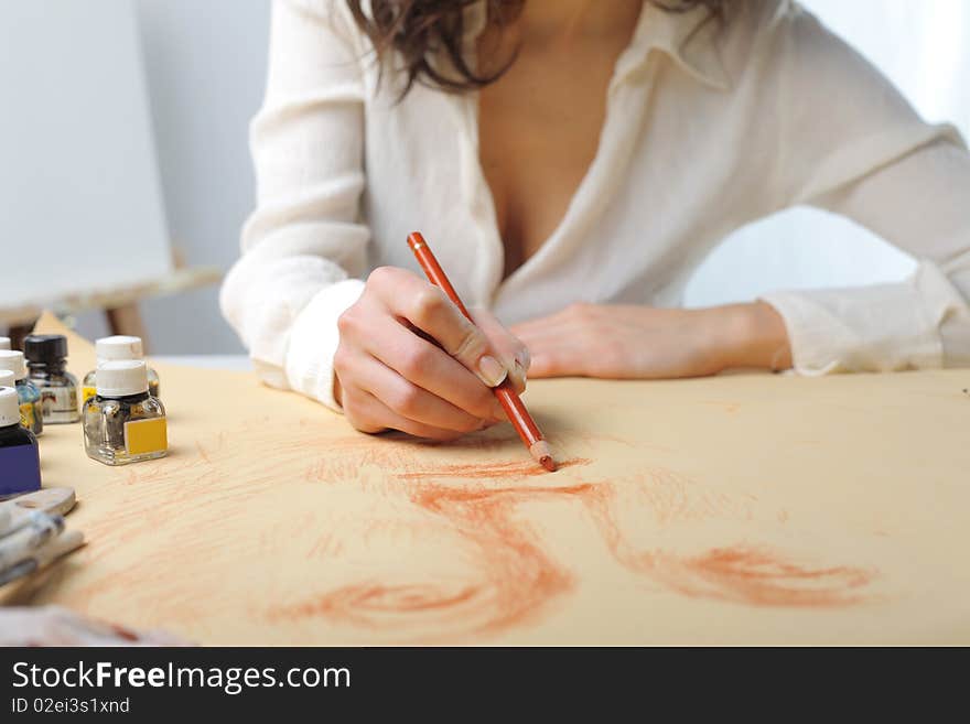 Detail on the hands of a young woman drawing