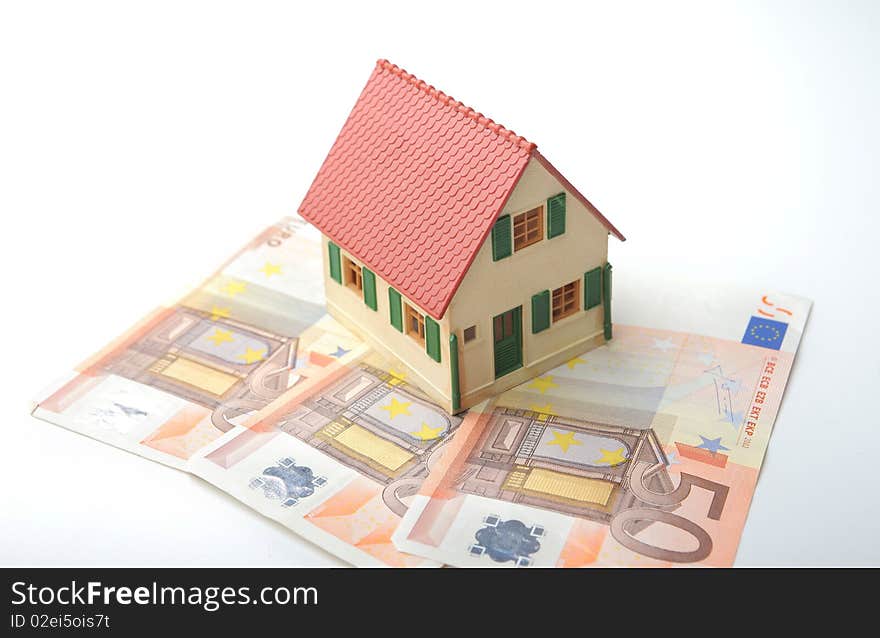 Model of a house standing on some banknotes. Model of a house standing on some banknotes