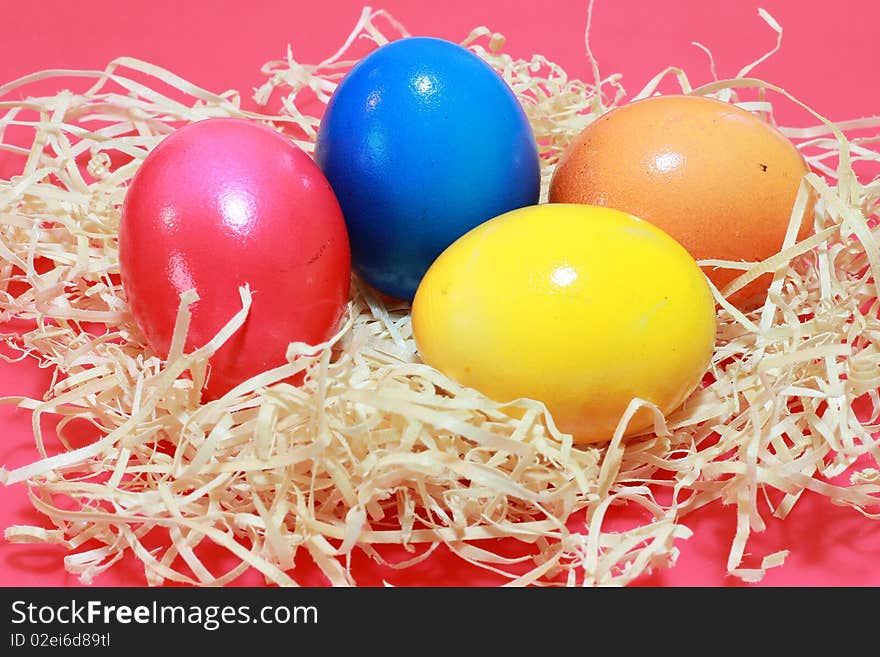 Four colored easter eggs, red, orange, blue and yellow