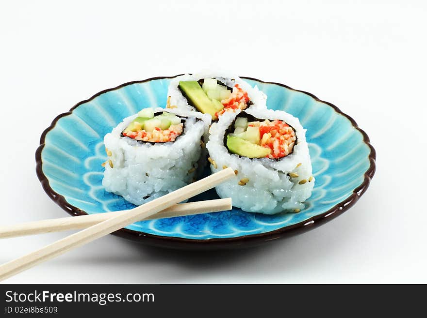 Three pieces of sushi and chopsticks on a blue dish