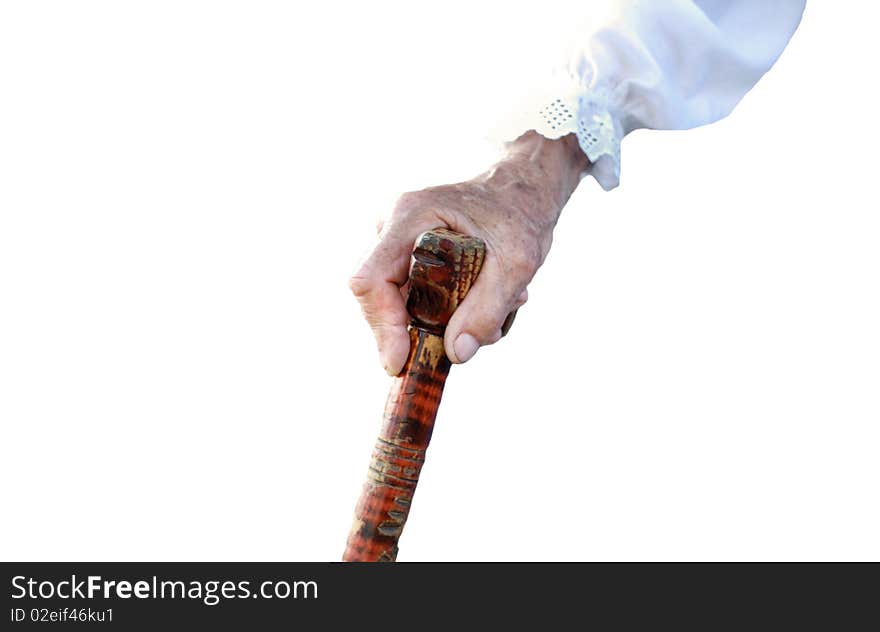 Hand of an old peasant woman holding a walking stick isolated on white background