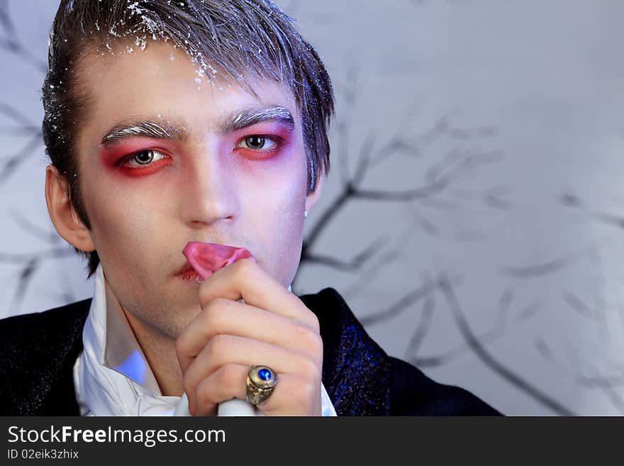 Portrait of a handsome young man with vampire style make-up. Shot in a studio. Portrait of a handsome young man with vampire style make-up. Shot in a studio.