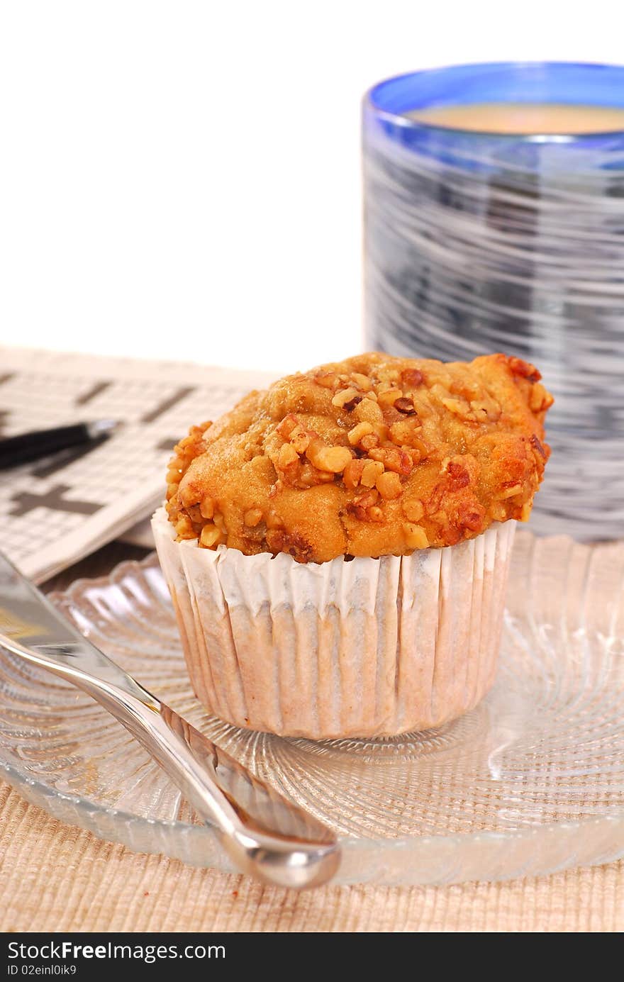 Freshly baked banana nut muffin with orange juice and crossword puzzle