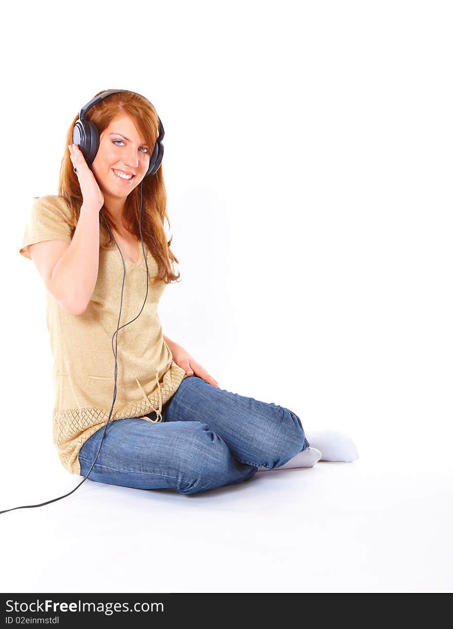 Portrait of happy young girl with headphones, sitting isolated on white background