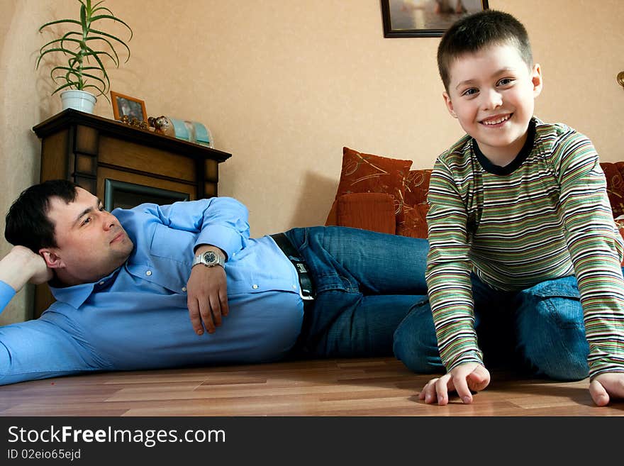 Happy family home: father and son playing on the floor. Happy family home: father and son playing on the floor