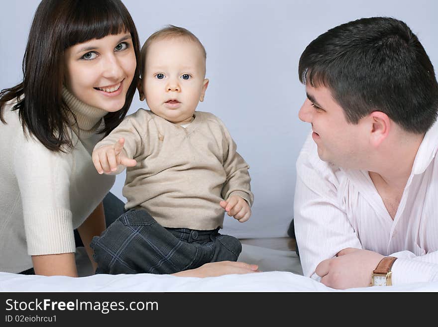 Happy family home: father, mother and baby lying on the floor and playing. Happy family home: father, mother and baby lying on the floor and playing