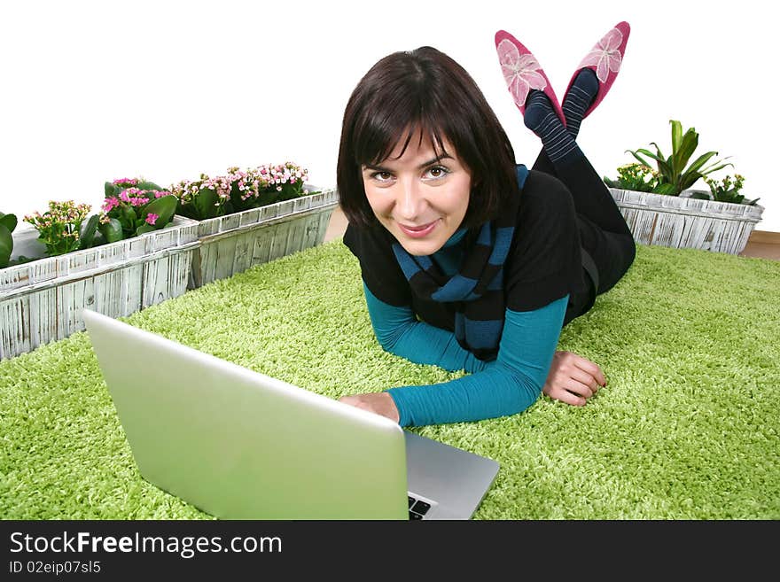 Young modern woman on laptop on green carpet at home. Young modern woman on laptop on green carpet at home